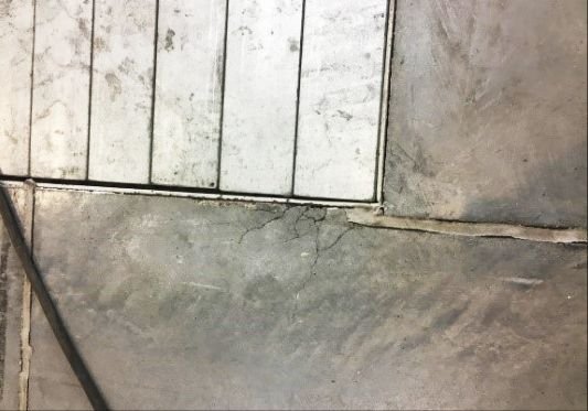 FOT. 7. Uszkodzona krawędź betonu przy korycie kablowym, masa elastyczna odspojona od betonu (hala nr 4); fot.: T. Majewski