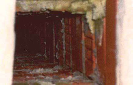 Fot. 21. Wnętrze kanału wylotowego komina wykonanego z dziurawki. Komin nie jest osłonięty od góry i deszcz wpada do widocznego kanału. Na jego ściankach wewnętrznych widać dziury w cegle. W każdy taki otwór wlewa się woda i spływa w dół do momentu, aż w.
