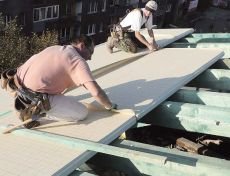 Fot. 2. Termoizolacja nakrokwiowa. Układanie płyt z PUR pokrytych membraną wstępnego krycia, która wystaje poza obrys płyt, a na dachu łączona jest taśmami samoprzylepnymi przyklejonymi fabrycznie do jej wystających krawędzi. 
