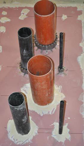 Fot. 1. Uszczelnienia przejść rur z tworzyw sztucznych w ścianie gipsowo-kartonowej, wykonane przy użyciu kołnierzy (trzy górne rury) oraz opasek (trzy dolne rury)