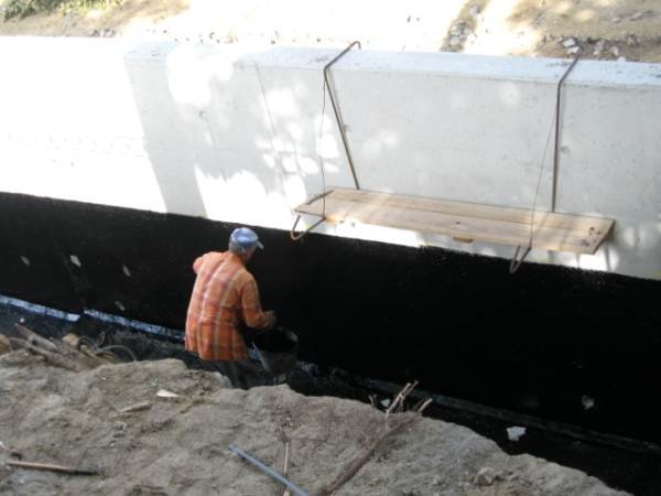Fot. 8. Pionowa izolacja strefy cokołu ściany betonowej odwadnianej rurkami poprzecznymi