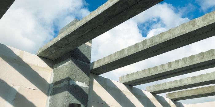 Widoczne na zdjęciu betonowe belki sprężone wzmocnione stalowymi cięgnami są podstawowymi elementami konstrukcyjnymi strop&oacute;w gęstożebrowych. Przestrzenie międzybelkowe mogą wypełniać pustaki betonowe bądź ultralekkie panele drewnopodobne. Uzupełnienie systemu stanowią układane na budowie siatki stalowe, pręty przypodporowe i nadbeton; fot. Rector