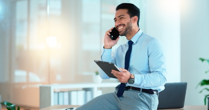mężczyzna w nowoczesnym pomieszczeniu rozmawia z uśmiechem przez telefon